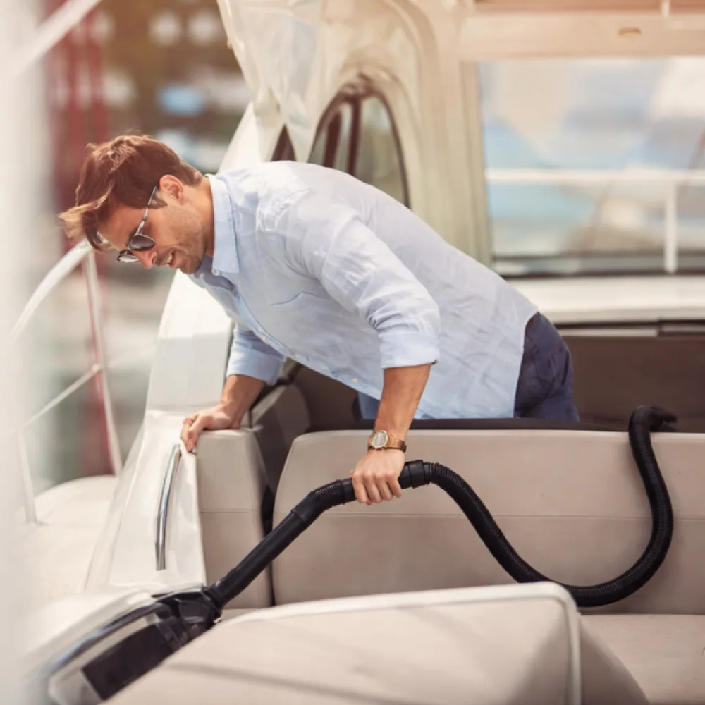 Boat owner vacuuming cabin seating with an InterVac marine vacuum