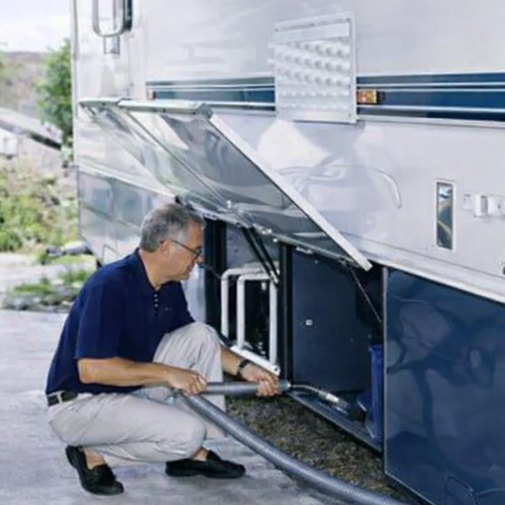 RV owner using an InterVac central vacuum hose at the coach bay inlet